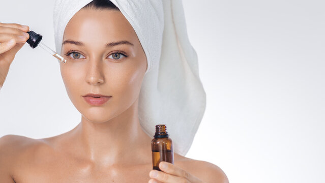 Skincare Serum Application: Woman With Towel Turban And Dropper Bottle