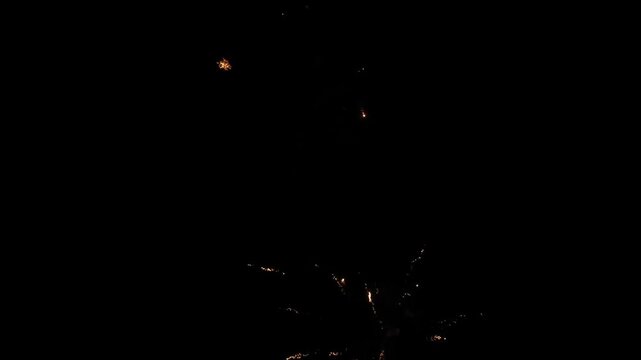 ​A 15 second high-definition video of vibrant fireworks illuminating the dark night sky. The clip features beautiful bursts of light, trails of golden sparks, and original ambient sound