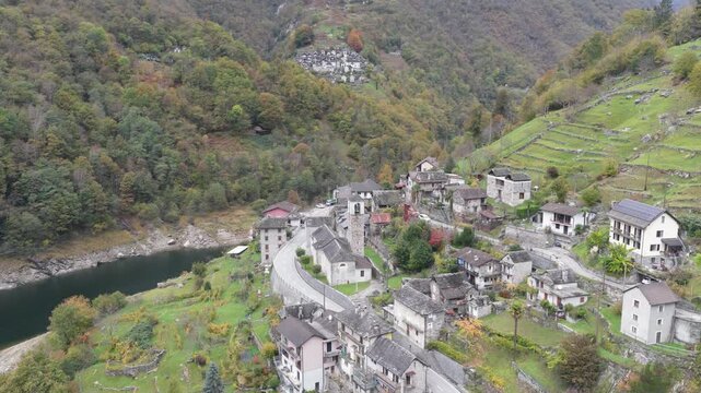 Aerial view of the stone houses of Lavertezzo nestling among forested hillsides and the Verzasca river, creating a scene of timeless beauty, Verzasca, Ticino, Switzerland.