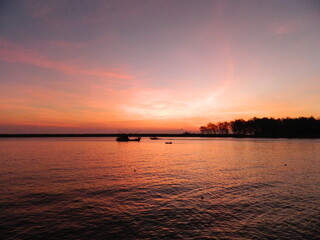 Fototapeta premium Sunrise over the beach with 3 fisherman boats