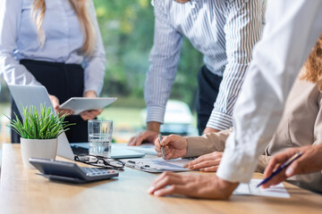 Unrecognizable business person analyzing graphs and taking notes.