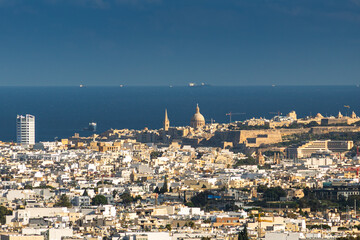 Fototapeta premium Malta from Above. High-angle panoramic view from the ancient bastions of Valletta looking over the dense urban landscape of Malta towards the distant Mediterranean Sea horizon. Valletta landscape.