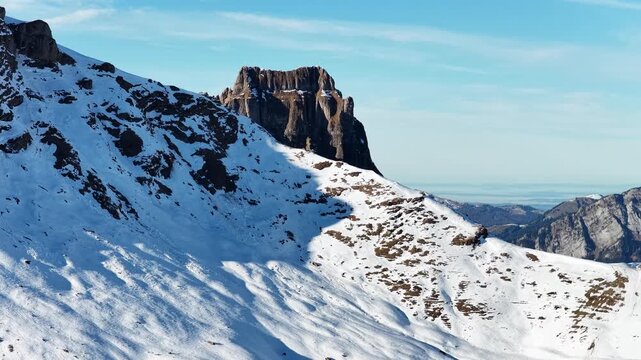 Snow covered alpine slope and rock formations in Churfirsten mountains