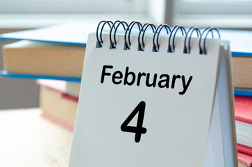 February 4 desk calendar on a clean workspace background