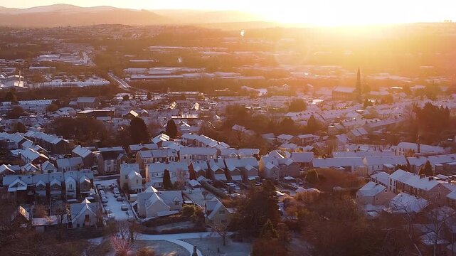 Morning Sunrise Aerial Panorama of Swansea Residential Area After Heavy Snowfall. Perfect for real estate, establishing shots of warm sun during colder months.