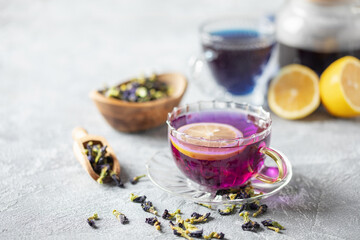Blue tea Anchan or Butterfly pea in glass cup with dry flower of clitoria. Purple tea with lemon. Asian drink