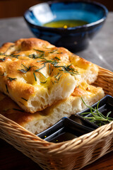 Freshly baked focaccia bread with rosemary and olive oil, served in a basket