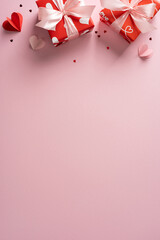 Pink vertical boxes with white ribbons sit at the top of a soft pink background, creating a...