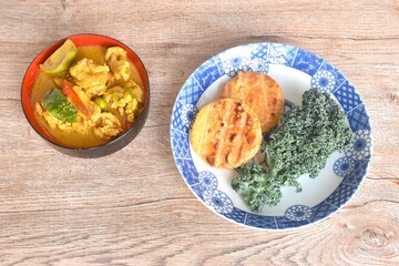 spicy boiled slice pork eggplant in curry soup eat couple grilled sticky rice with egg and curly kale vegetable on plate
