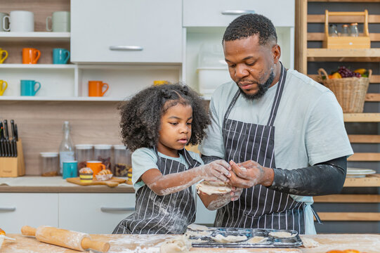 african afro black daughter kids with dad father and mom enjoy cooking class family funny internet learning by laptop . Black african family afro hair look computer for learn cooking in the kitchen