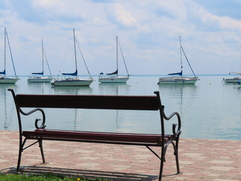 Lake landscape with bench and ketches