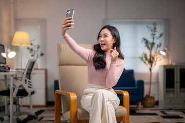 Young asian businesswoman taking a selfie with smartphone at home office