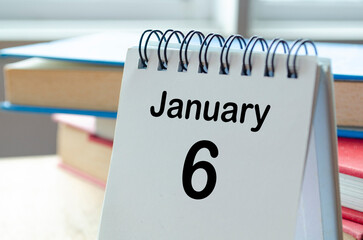 Desk calendar showing January 6 on blur office background