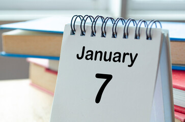 Desk calendar showing January 7 on blur office background