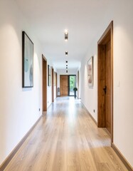 A long, modern interior hallway with light wooden floors, white walls, and multiple doors.