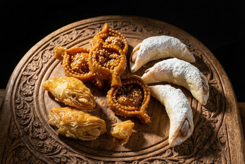 Selecci&oacute;n de dulces tradicionales marroqu&iacute;es sobre bandeja de madera tallada