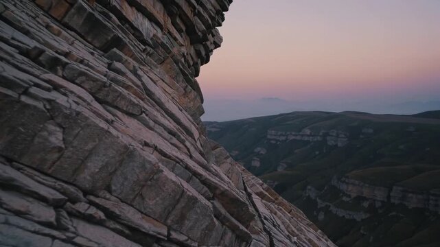 Twilight rocky layers, Serene evening scene showcasing layered geology against violet sky, Expansive valley view featuring folded rock strata beneath twilight and tranquil dusk atmosphere