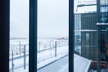 View from the window of a modern office building on the railway station and winter frozen river