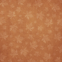 Soft autumn leaf pattern on textured fabric background in warm brown and beige tones. Natural, cozy fall backdrop ideal for stationery, home decor, and seasonal design.
