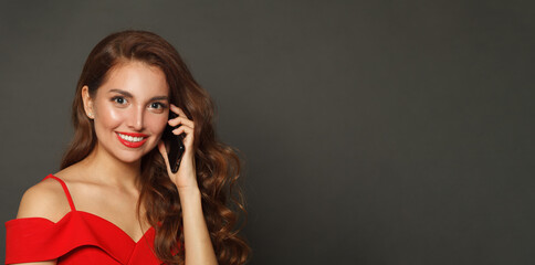 Happy woman with long hair and make-up on black background. Gorgeous woman with curly hairstyle