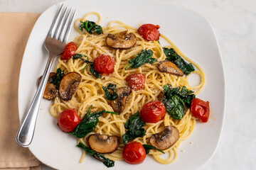 spaghetti top with tomatoes, spinach and mushrooms