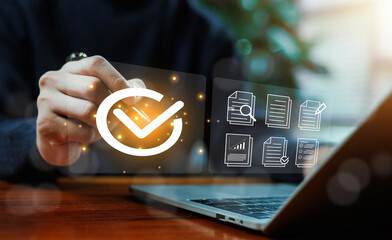 Business professional approving digital documents with check mark interface, verifying workflow on virtual screen over laptop, concept of approval process, quality control, compliance.