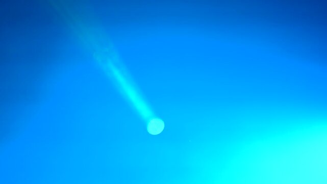Green laser beam projects from a light source, illuminating the dark space with vibrant light, showcasing the gradual expansion and intensity of the beam's glow and spread