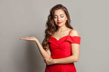 Gorgeous model woman holding empty open palm hand and smiling on white background