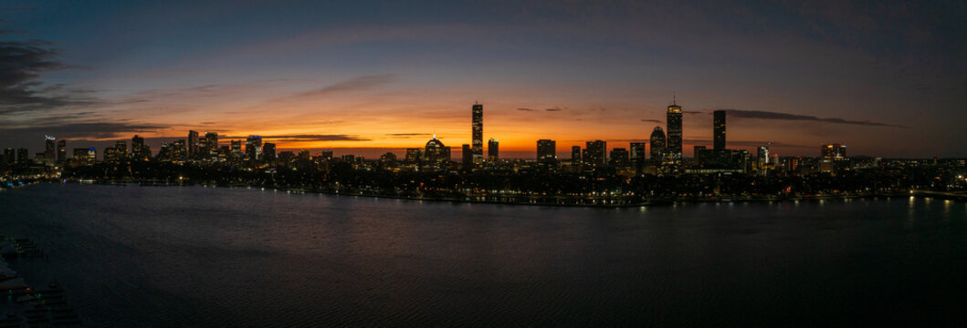 Aerial view of the city skyline with the Custom House Tower, Prudential Tower, and John Hancock Tower illuminated at twilight, Boston, Massachusetts, United States.