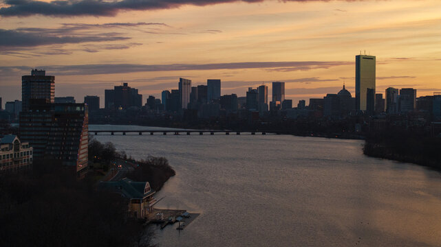 Aerial view of the Charles River reflecting the warm glow of sunset beneath the Boston skyline, including the iconic Prudential Tower, Boston, Massachusetts, United States.