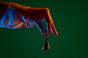 Hand moving queen across chessboard during match. Concept of operational management, tactical adjustment, business process change, strategy execution, leadership action.