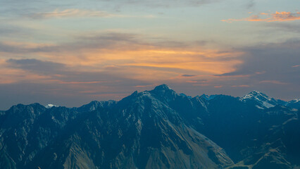 Majestic mountain range under warm sunset sky with dramatic evening light.