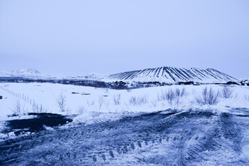 Obraz premium Frosted volcanic landscape with pathways to crater formations