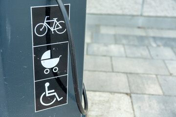 Pictograms on the sidewalk depicting a bicycle, a stroller, and a wheelchair