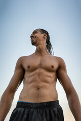 Smiling athletic man outdoors against a light blue background