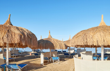 Straw umbrellas, sun loungers and windbreaks on the beach in Hurghada, Egypt.