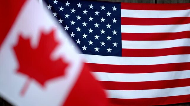Vibrant display of Canadian and American flags waving in unison symbolizing