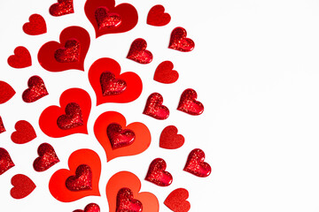 Red heart shape cutouts and glitter stickers on white background for Valentines Day greeting card...