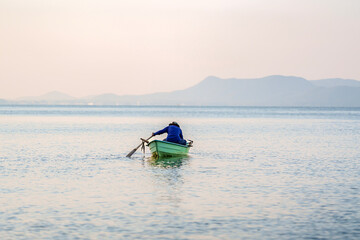 Local fishermen heading out to fish on traditional fiberglass boats in the early morning.
