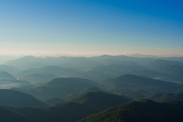 Beautiful of layered green mountain ranges with warm evening sunlight in Northern Thailand.