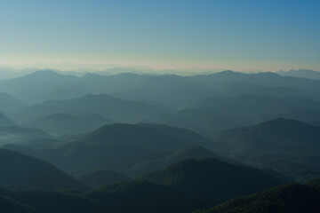 Beautiful of layered green mountain ranges with warm evening sunlight in Northern Thailand.