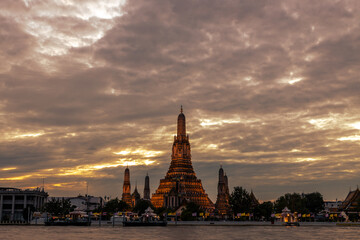 Naklejka premium An abstract, blurred background of nighttime lights along the Chao Phraya River in Bangkok, with Wat Arun, a popular tourist attraction visited by travelers from around the world, in the background.