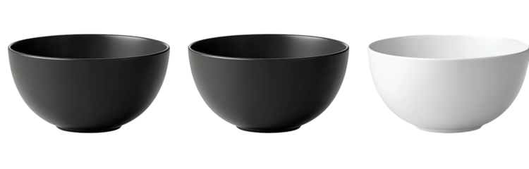 Three minimalist ceramic bowls, two black and one white, arranged in a row against a black background