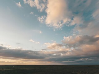 Dramatic cloudy sky over vast open landscape at sunset