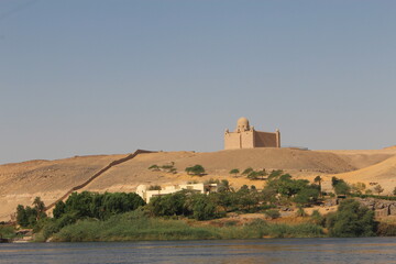 Fototapeta premium Ancient Egyptian temple complex on a hill overlooking the Nile River in a desert landscape