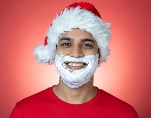 Man smiling with santa hat shaving cream beard