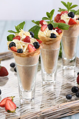 Crispy crepe cones filled with whipped cream, strawberries, blueberries, almond slices, and fresh mint.