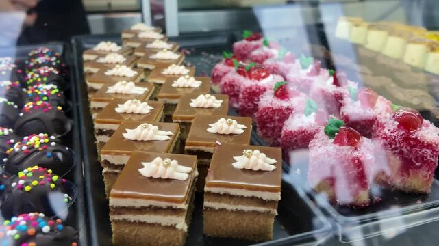 Camera video of assorted cakes and desserts in glass display