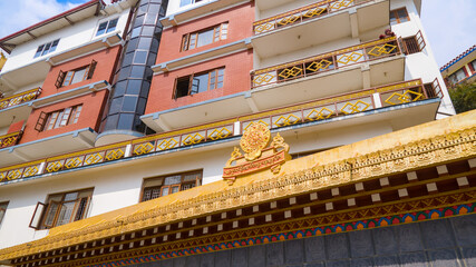A modern building featuring traditional Buddhist decorations and balconies, with a clean, linear...
