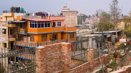 Fototapeta premium A diverse urban view with varied buildings and brick walls, reflecting everyday architecture in a Nepali city setting.